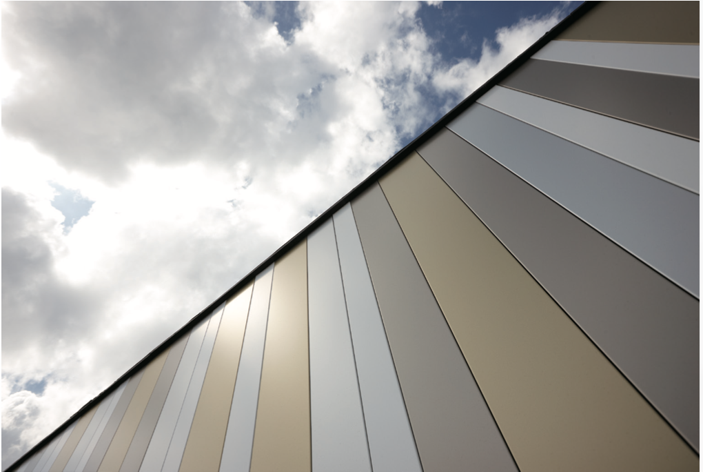 Long aluminium façade panels running diagonally against a cloudy sky